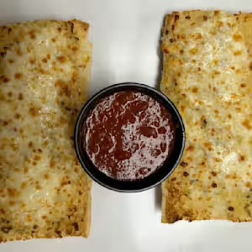Two rectangular cheese breadsticks with a side of marinara sauce for dipping.
